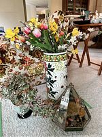 Full view showing the porcelain umbrella stand with artificial colorful flowers, small succulent pot, and triangular terrarium with dried flowers on carpet.
