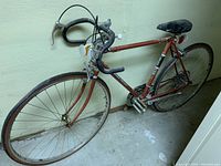 Full side view of the red Koko Sport road bike showing the frame, saddle, drop handlebars, and rear rack
