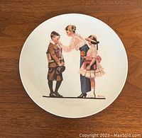 Front view of a Norman Rockwell collector's plate depicting a woman adjusting a boy's tie and a girl holding a book, all in vintage school attire.