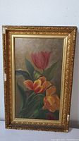 Frontal view of the oil painting showing floral composition of red and yellow-orange tulips in a gold ornate frame.