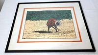 Framed lithograph showing a woman planting in the field wearing red and white hat with orange and white double matting