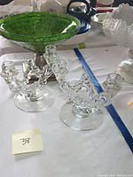 Pair of clear glass three-arm candelabras shown beside the green mosaic bowl on a pewter footed base