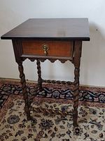 Full view of vintage wooden side table showing top surface, drawer with brass pull and barley twist legs