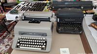 Two vintage typewriters side by side on a table, Royal 440 on left and Remington Rand Noiseless on right.