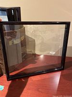 Single black presentation frame showing slight wear and scuff marks on frame edges.