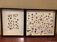 Two black rectangular frames containing assorted collector pins mounted on white backgrounds. Frames show some wear. Pins vary in themes and design.