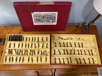 Open box with two trays showing assorted lead soldier figures in rows, some slots empty