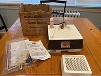 Main Super Star II diamond glass grinder unit set on table with original box behind it, manual and accessories laid out beside it.