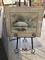 Framed watercolour artwork by Colin Righton depicting B.C. Place and False Creek with gold aluminum frame on black easel stand.