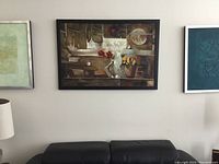 Framed large abstract painting hung above black leather couch showing overall look on the wall
