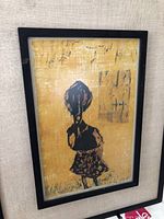 Front view of framed mixed media artwork of a stylized figure on yellow background.