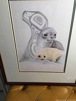 Close-up photo of the framed Sue Coleman art print showing seal mother and pup with Indigenous art whale