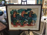 Framed limited edition lithograph with six colorful canvasback duck heads in stylized forms, signed by artist Wallace, presented on easel in showroom setting.