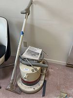 Bissell deep cleaning machine base with hose, wand, and manual seen from front angle