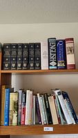 Two shelves with various literature, historic, poetry, and dictionary books in hard and soft covers.