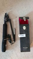 Bell & Howell boom microphone with black foam windscreen, adjustable arm, cable with 1/4 inch plug, and leather carrying case with snap closure and red interior.