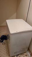 Photo of a white rectangular chest freezer showing top closed lid with minor dirt marks on the sides.