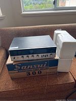 Sansui amplifier from front angle showing front panel and controls with original box and styrofoam inserts.