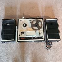 Top view of Sony TC-252 reel-to-reel tape recorder with two speakers, showing reels and control panel.