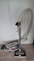 Full view of Tri Star canister vacuum cleaner with attached hose and Turbo Brush cleaning head.