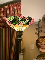 Full view of stained glass style torchiere floor lamp showing the floral pattern glass shade and metal stand.