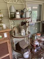 Full view of the metal shelving unit showing its weathered condition and contents.