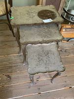 Top view of the three nested tables showing ornate carved tabletops and shapes