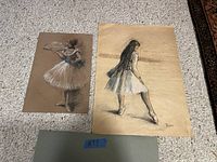 Both unframed drawings side by side on carpet