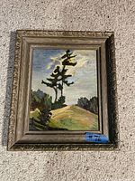 Front view of framed oil painting showing landscape scene and decorative frame