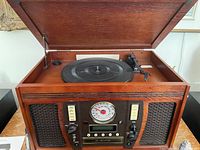 Photo of the open wooden music centre showing the vinyl turntable and controls.