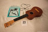 Ukulele and instructional book laid out showing the full front of both items.