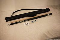 Full lot display showing two-piece pool cue stick, black fabric carrying case, and two cube chalks on a beige table.