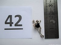 Single vintage sterling silver frog pin with onyx body and marcasite details placed next to a ruler showing length about 1.7 inches.