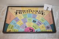 Full view of the game board inside box with title 'The Phoenixville Trivia Game' showing the concentric circle layout of trivia questions and categories.