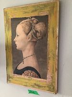 Side angle view of a 20x14 inch framed print of a woman's profile with a yellow and green distressed frame.