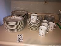 Full view of Arzberg dinnerware set including plates, bowls, and cups arranged in stacks.