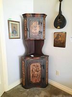 Full front view of the painted corner cabinet in a room corner showing both upper and lower cabinets.