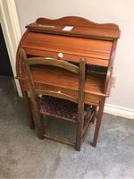 Child size wood roll-up desk and wooden chair showing overall shape and condition.