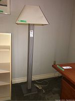 Full view of floor lamp showing white tapered shade on striped column base