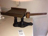 Side view of the vintage scale showing brass platform and black cast iron base.