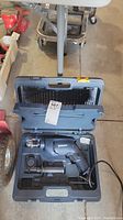 Mastercraft blue corded drill with side handle in open plastic case showing drill and accessories inside.