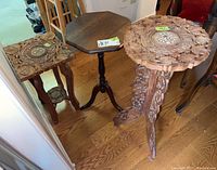 Photo showing all three occasional tables with visible differences: two carved wood and one octagonal pedestal table.