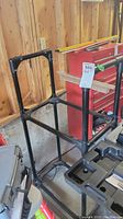 Full view of the black plastic modular tire rack showing the rectangular base and tall vertical side supports.