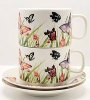 Two Butterfly Garden tea cups stacked on two saucers, showing butterfly and floral patterns around cups and saucer rims.