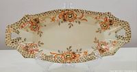 Full view of the oblong dish showing the floral pattern and gold star decorations with handles on each side