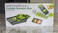 Box front showing the Multi-Function 6-in-1 Foldable Mandolin Slicer, model SL-7509, with main unit and blades displayed