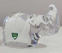 Front and side views of the clear crystal rhinoceros paperweight with Orrefors Sweden green label.