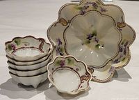 Set of one large and six small footed vintage Japanese porcelain nut bowls with hand-painted purple flower design.