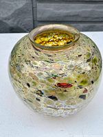 Front view showing rounded shape and multicolor oil spot iridescent pattern on glass vase