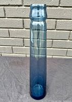 Front view of tall slim blue gradient glass vase with smooth cylindrical shape and bubble texture.